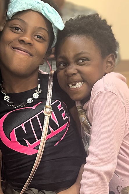 Two girls smiling together in the newsletter photograph